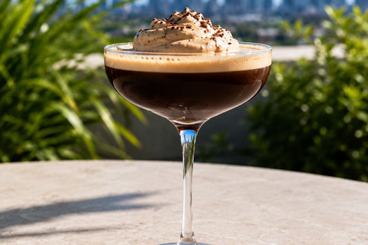 Espresso Martini topped with Espresso Martini whipped cream on a table overlooking the city.